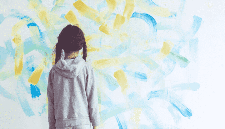 girl looking at paint streaks on a wall