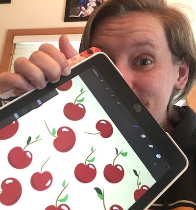 Diana Fitts with ipad with cherry pattern drawing on it