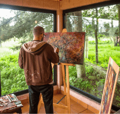 man with large painting on easel