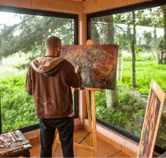 man with large painting on easel