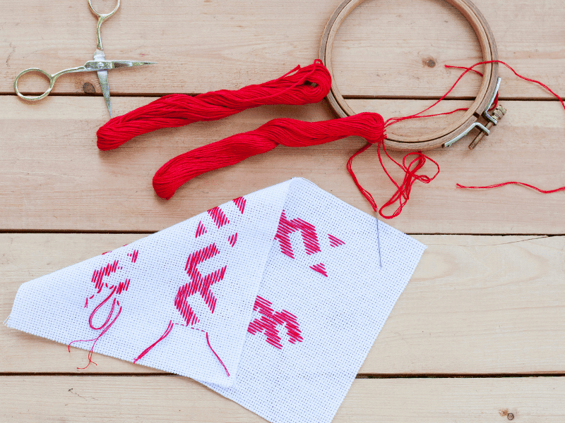 red embroidery thread with hoop and project