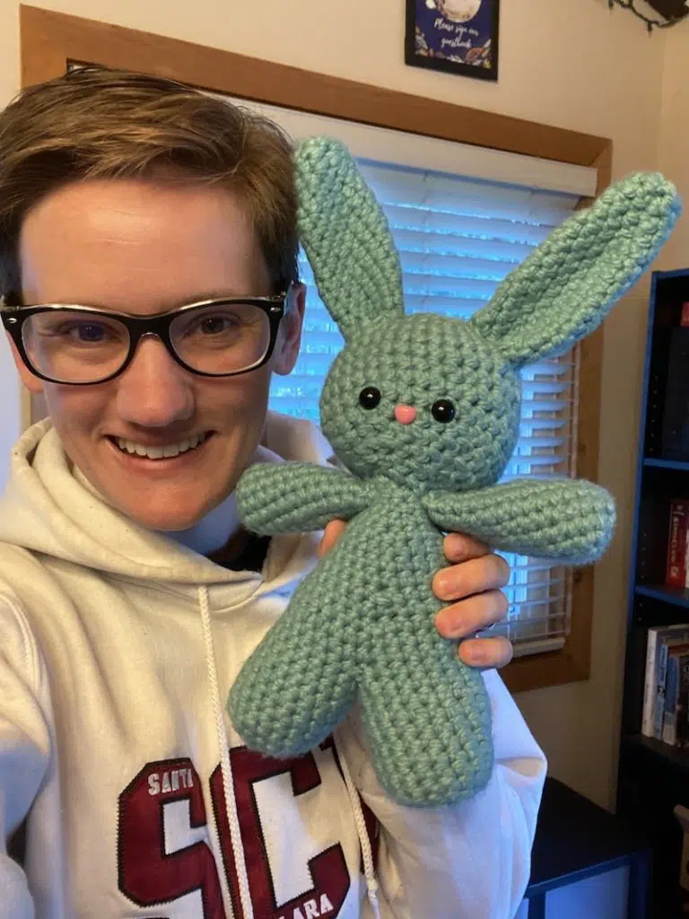 woman holding crochet blue rabbit