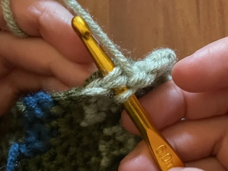 putting crochet hook under legs of next stitch