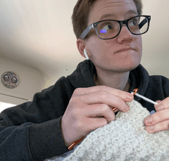 woman working on crochet without looking